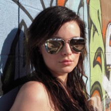 Morena con gafas cerca de la pared foto para descargar avatar