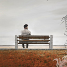 Einsamer Mann auf einer Bank auf der Seite