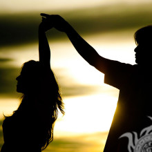 Couple dancing in the sunset light icon