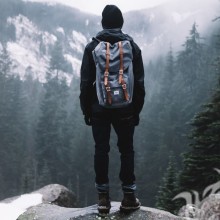 Парень с рюкзаком в горах фото со спины