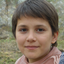 Foto de un niño con pelo corto en la naturaleza.