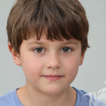 Фотография маленького веселого мальчика шатена на светлом фоне