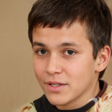 Фотографія хлопчика брюнета з короткою стрижкою на сірому тлі