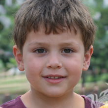 Foto de um menino de cabelos castanhos com um penteado curto na natureza