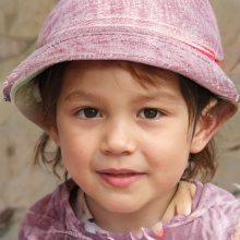 Das Gesicht eines kleinen modischen Mädchens in einem schönen Hut