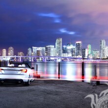 Завантажити фото машини на березі з видом на нічне місто