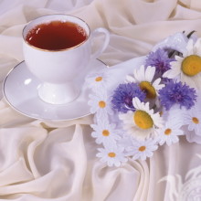 Xícara de chá com flores de camomila