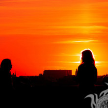 Menschen vor dem Hintergrund der Stadt treffen das Sonnenaufgangfoto