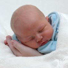 Маленький ребенок спит в руках
