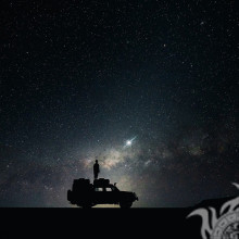 Звёздное небо и парень на крыше автомобиля на страницу