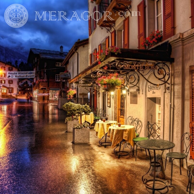 Tische in der Nähe des Cafés auf dem abendlichen Straßenbild Gebäude