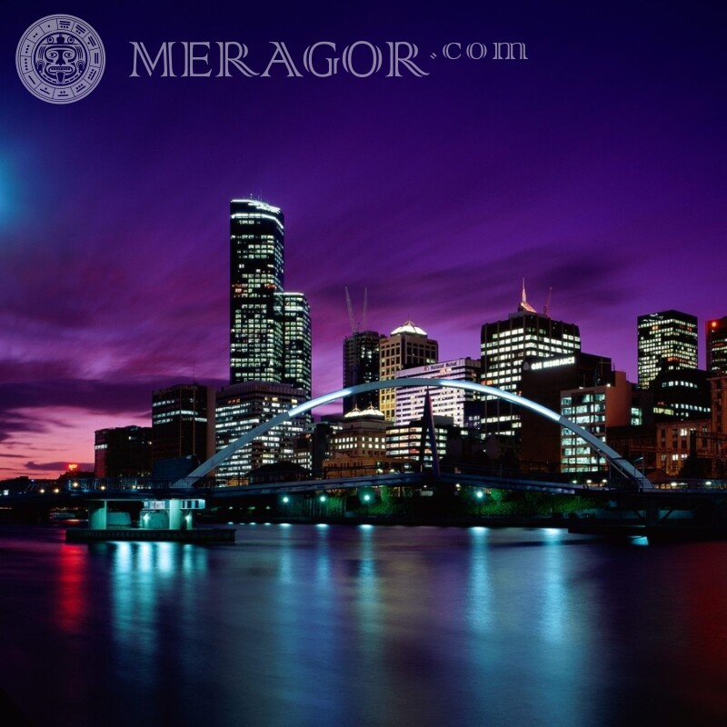 Night city and bridge in lights on the shore on the profile picture Buildings