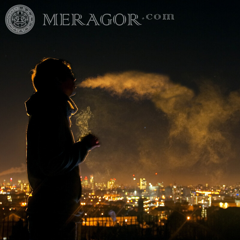 Schattenbild eines Kerls auf dem Hintergrund einer Nachtstadt Silhouette Junge Raucher