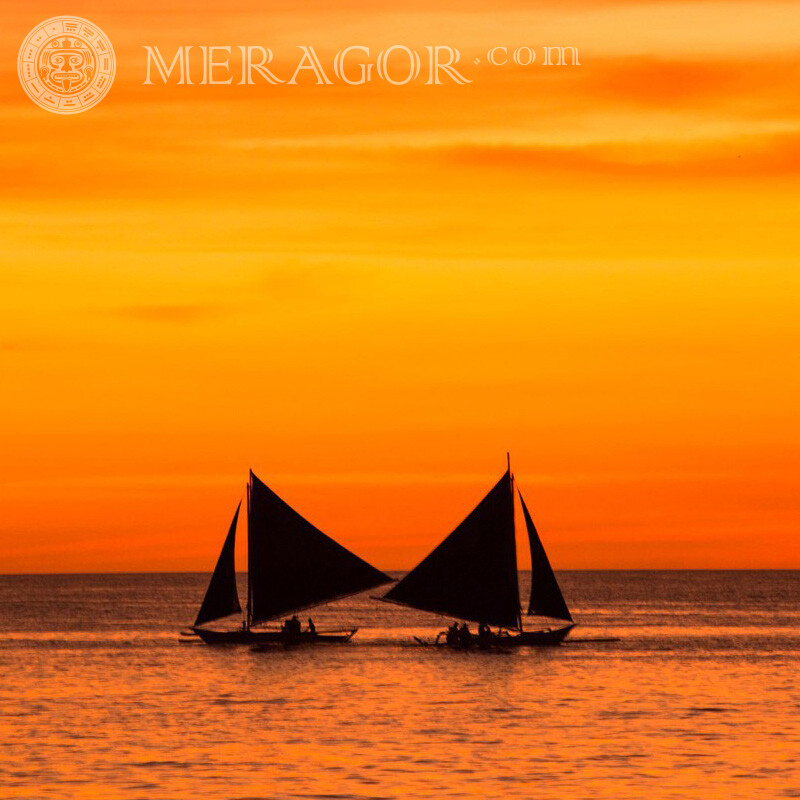 Photo de deux petits voiliers et coucher de soleil sur la mer Transport